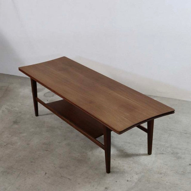 Mid-century British teak coffee table by Richard Hornby with magazine rack and tapered legs, smooth wood grain surface,.