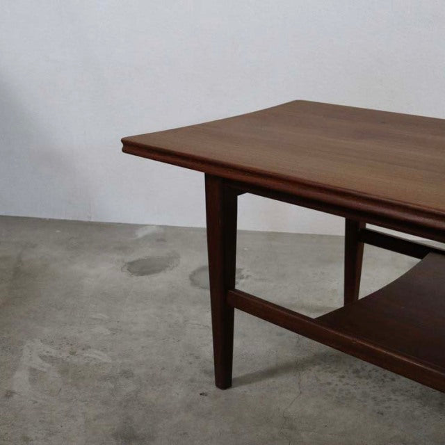 Vintage mid-century British teak coffee table by Richard Hornby with magazine rack and tapered legs, showcasing rich wood.