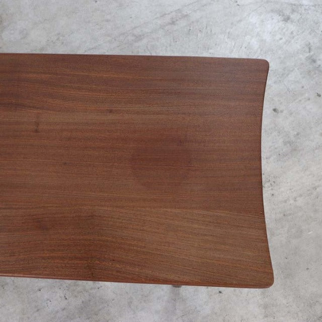Mid-century British vintage teak coffee table top with smooth wood grain and curved edges.