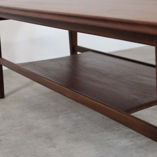 Mid-century British vintage teak coffee table by Richard Hornby with smooth wood grain and integrated magazine rack beneath.