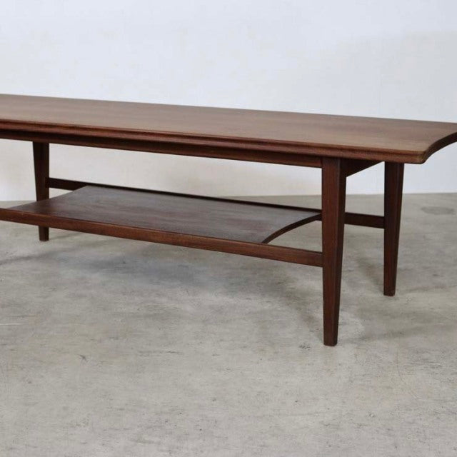Mid-century British teak coffee table by Richard Hornby with magazine rack, tapered legs, and visible wood grain.