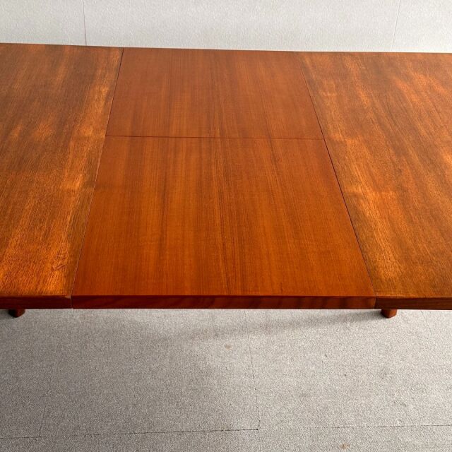 Mid-century British vintage teak oval dining table with rich wood grain and tapered legs from Denmark.