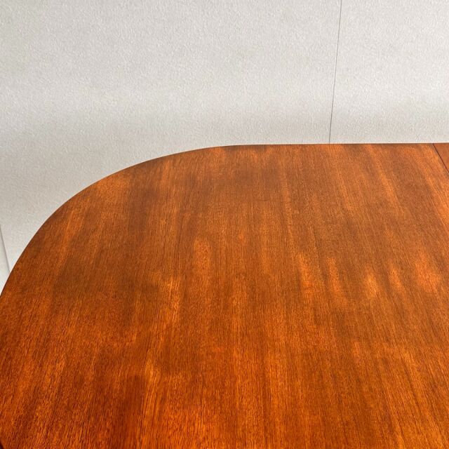 Mid-century British vintage teak oval dining table with smooth wood grain and rounded edges.