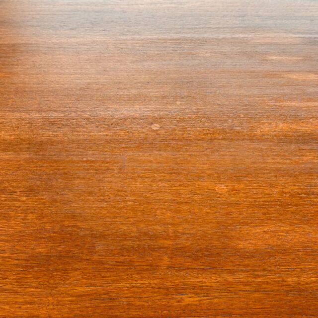 Vintage teak oval dining table top showing rich wood grain and smooth mid-century British craftsmanship finish.
