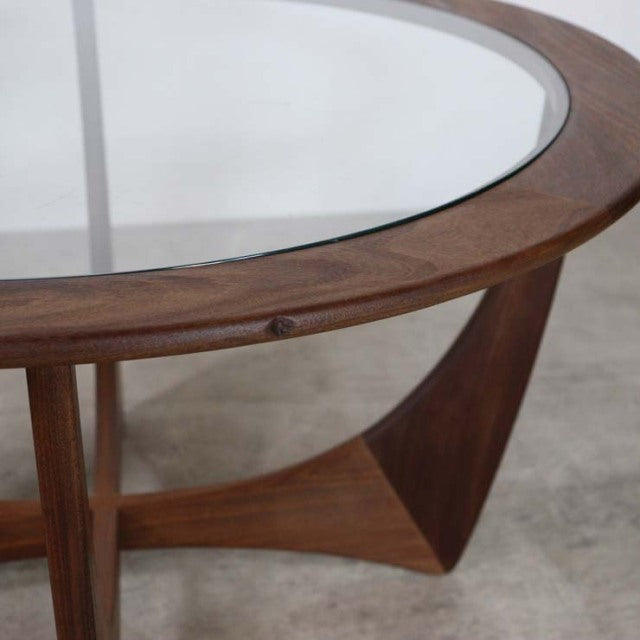 Vintage British G-Plan mid-century teak coffee table with round glass top and curved lower shelf.