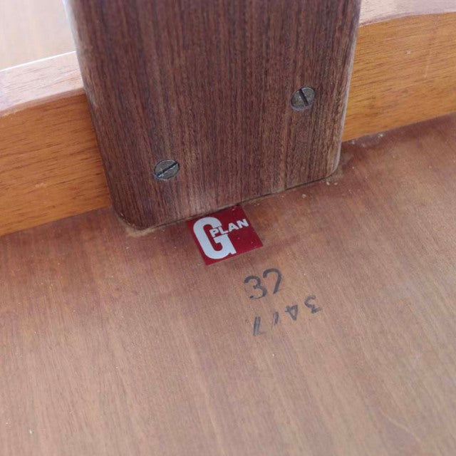 Close-up of teak wood grain, G-PLAN vintage British mid-century dining table label on underside.