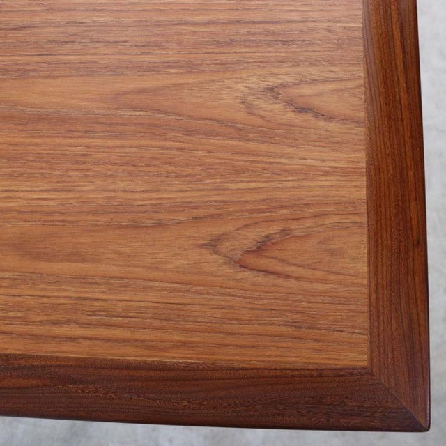 Close-up of vintage teak G-Plan dining table corner showcasing rich wood grain and mid-century British craftsmanship with.