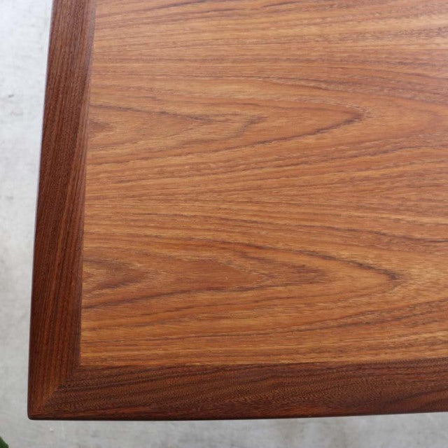 Vintage British mid-century teak dining table top showing rich wood grain and beveled edge detail.