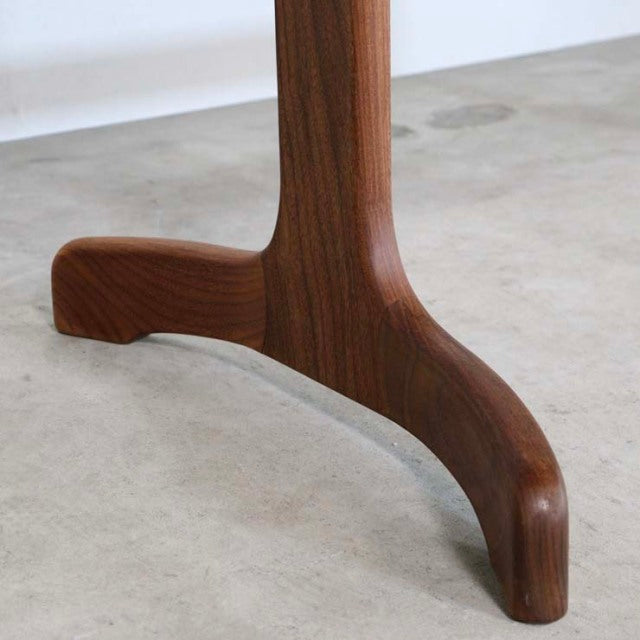 Close-up of vintage British mid-century teak dining table leg with smooth curved design and rich wood grain, Danish-inspired .
