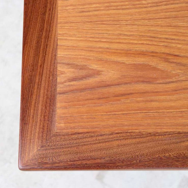 Close-up of vintage British teak dining table corner with rich wood grain and precise mid-century craftsmanship.