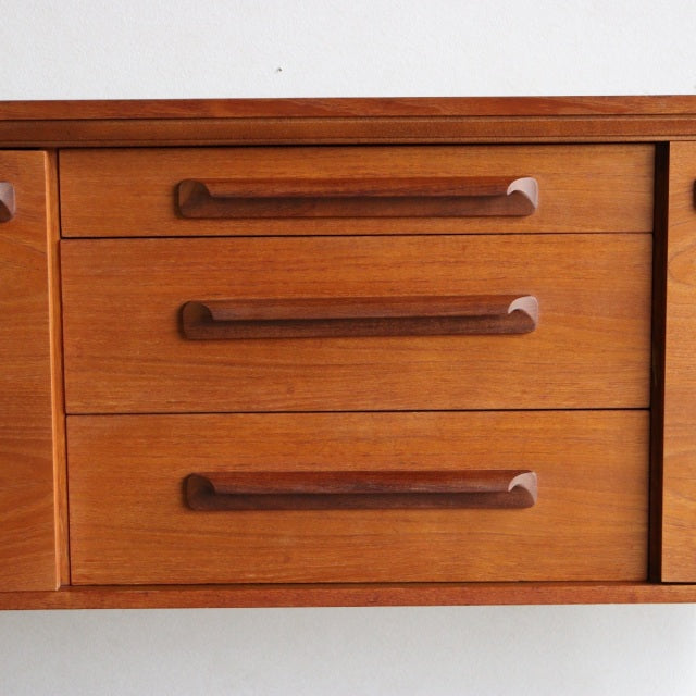Mid-century teak sideboard by William Laurence with three wide drawers and sleek wood grain detailing, British-Danish.