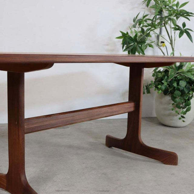 Mid-century British G-PLAN teak dining table with visible wood grain and slender T-shaped legs, vintage Denmark design.