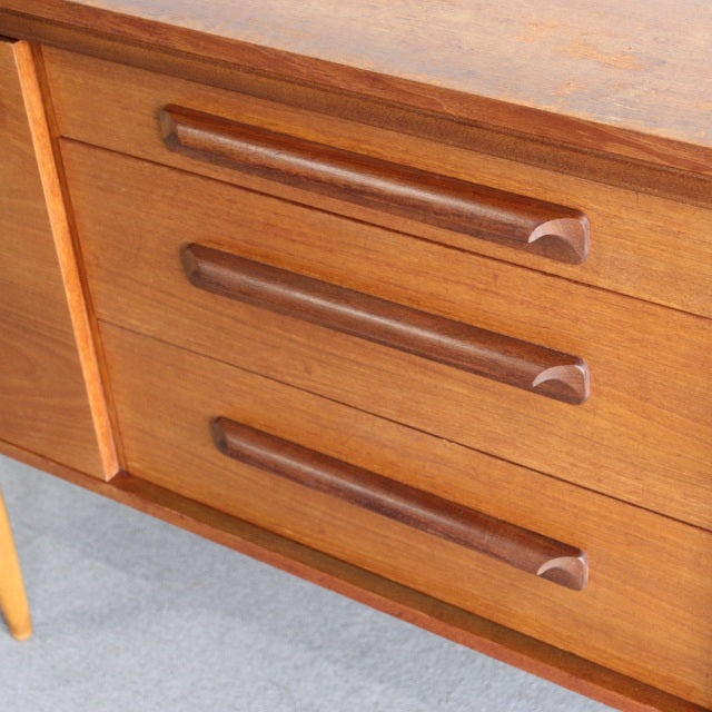 Mid-century British teak sideboard by William Laurence with rich wood grain and sculpted drawer handles.