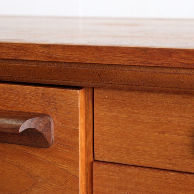 Mid-century British teak sideboard by William Laurence with smooth wood grain and sculpted drawer handle.