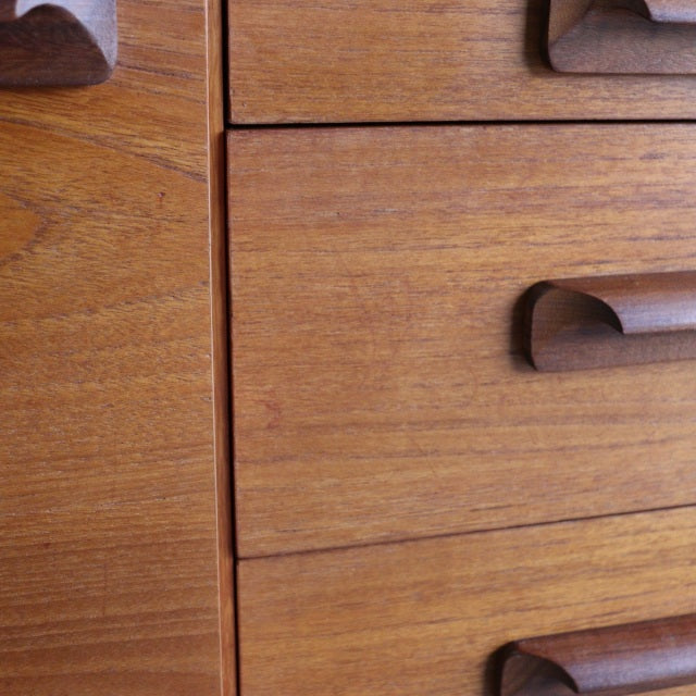 Close-up of vintage teak sideboard by William Laurence showing smooth wood grain and curved mid-century British handles.