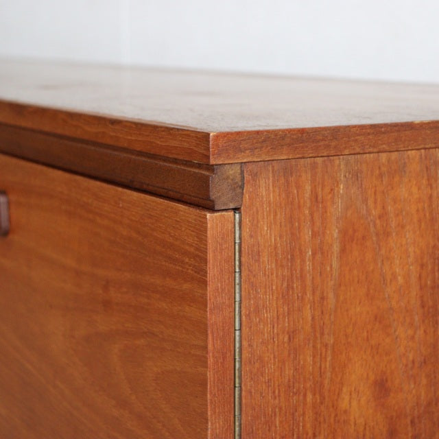 Close-up of vintage teak sideboard corner showing rich wood grain, tight joints, and mid-century British craftsmanship.