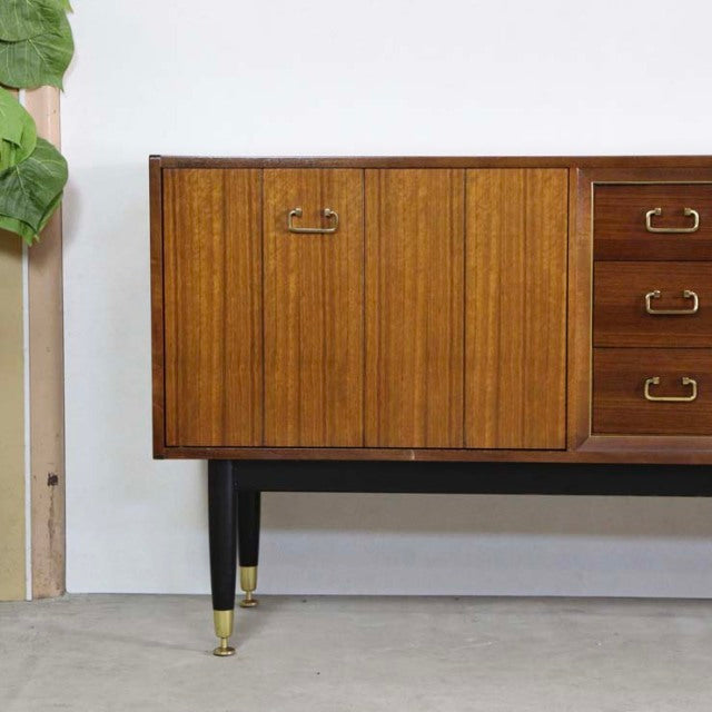 Vintage teak G-PLAN Goldstamp sideboard with vertical wood grain, brass handles, and tapered black legs with brass caps,.