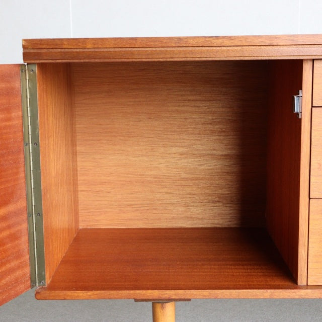 Open vintage teak sideboard compartment showing smooth wood grain interior, mid-century British design by William Laurence,.