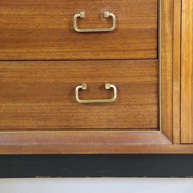 Close-up of vintage teak wood sideboard drawers with visible wood grain and brass handles, showcasing mid-century British.