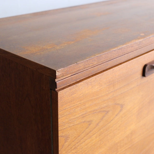 Close-up of vintage teak sideboard corner showcasing rich wood grain and smooth mid-century British craftsmanship by William .