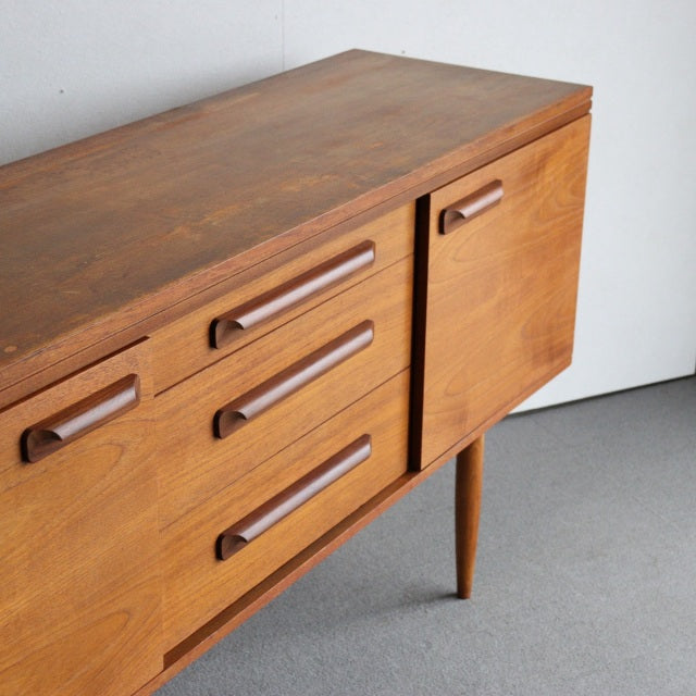 Vintage mid-century teak sideboard by William Laurence from Denmark with smooth wood grain, tapered legs, and rounded.
