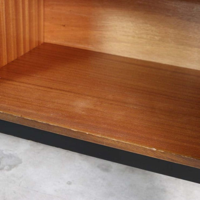 Close-up of vintage teak wood grain on British mid-century G-Plan sideboard shelf with smooth finish and black trim edge.