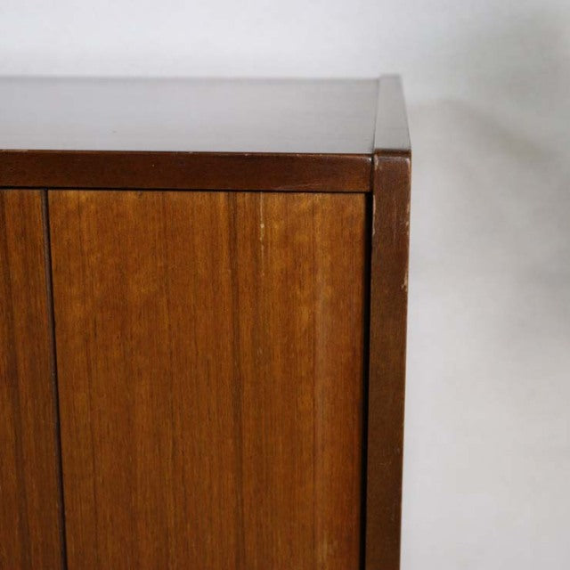 Close-up of vintage British mid-century teak sideboard corner showing smooth wood grain and crisp edges.