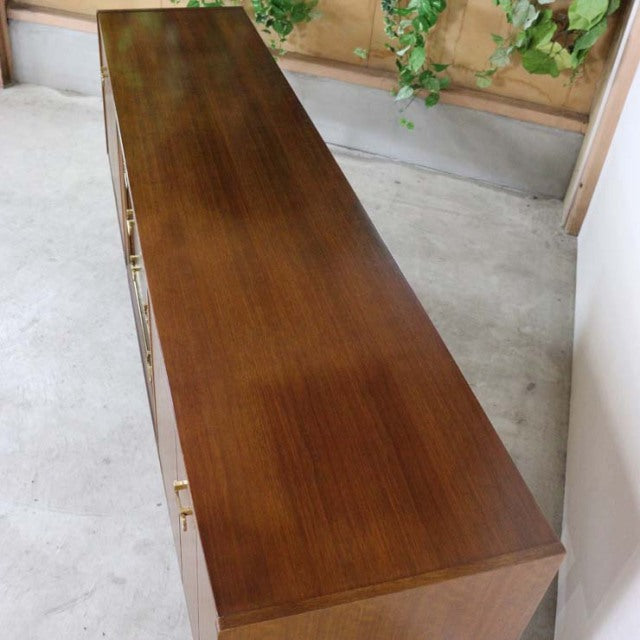 Long vintage teak G-Plan Goldstamp sideboard with sleek mid-century British design, visible wood grain, and tapered legs.