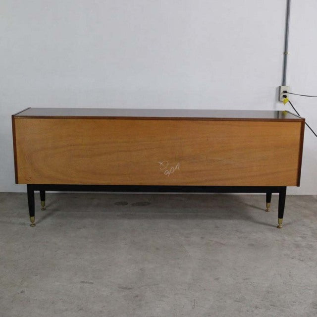 Vintage British mid-century teak sideboard by G-PLAN GOLDSTAMP, sleek wood grain, tapered black legs with brass feet,.