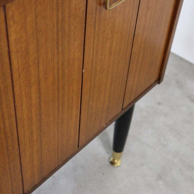 Vintage teak G-Plan mid-century British sideboard with vertical wood grain and black tapered legs with brass caps.