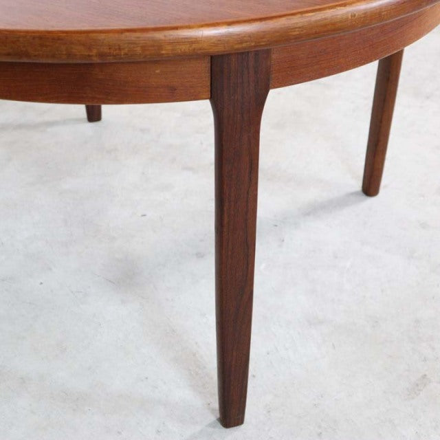Vintage British mid-century teak dining table leg with smooth wood grain and tapered design.