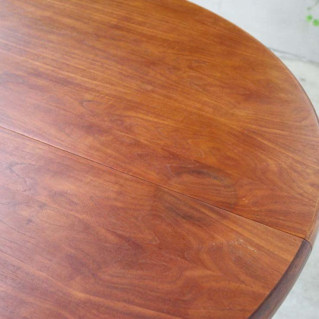 Round vintage teak dining table top with rich wood grain and smooth mid-century British design.
