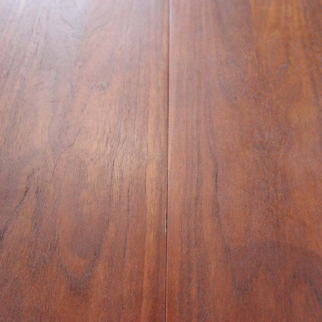 Close-up of vintage British mid-century teak dining table surface showing rich wood grain and warm brown finish.