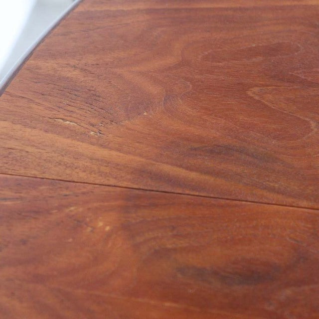 Close-up of vintage British mid-century dining table top in rich teak wood with visible grain patterns and smooth finish.