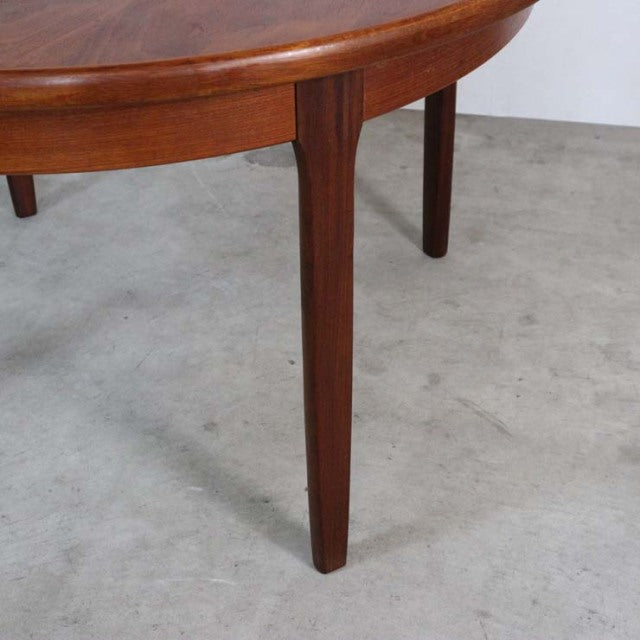 Vintage British mid-century teak dining table leg with smooth wood grain and tapered design.