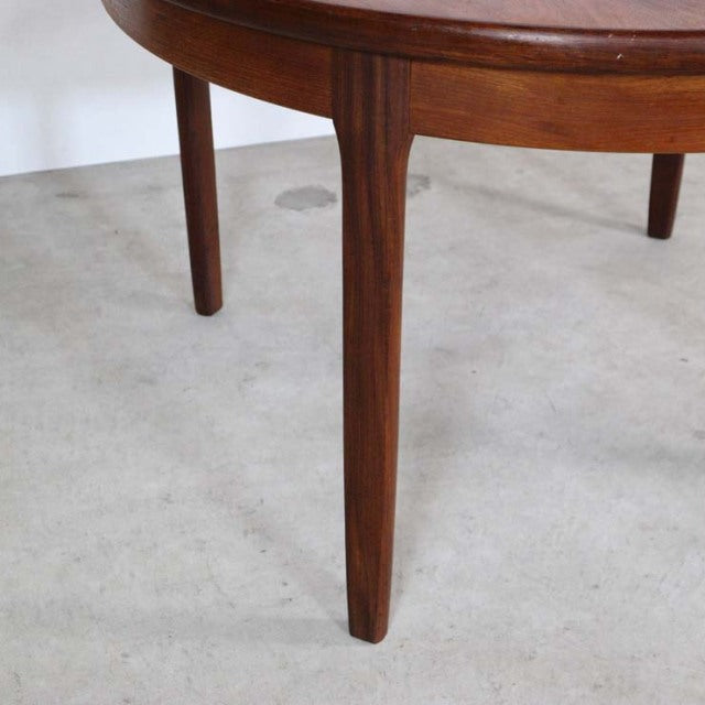 Mid-century British vintage teak dining table leg with rich wood grain and tapered round profile.