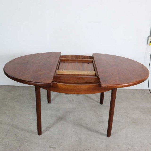 Mid-century British vintage teak dining table by Elliotts of Newbury with round expandable top and tapered legs.