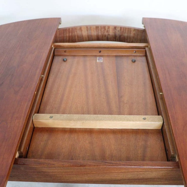 Vintage British mid-century teak dining table extension mechanism with smooth wood grain and sturdy frame.
