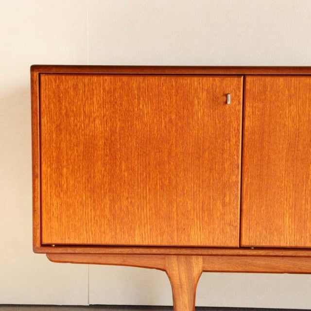 Vintage teak sideboard by Younger with smooth grain, British mid-century design, slender tapered legs, and clean rectangular .