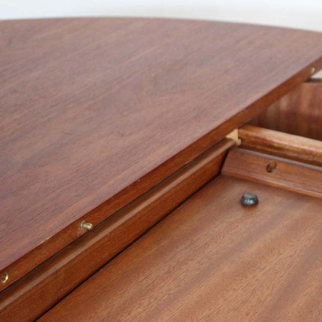 Mid-century vintage teak dining table by Elliotts of Newbury with smooth oval top and wood grain detailing.