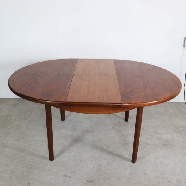 Oval mid-century vintage teak dining table by Elliotts of Newbury with smooth wood grain and tapered round legs.