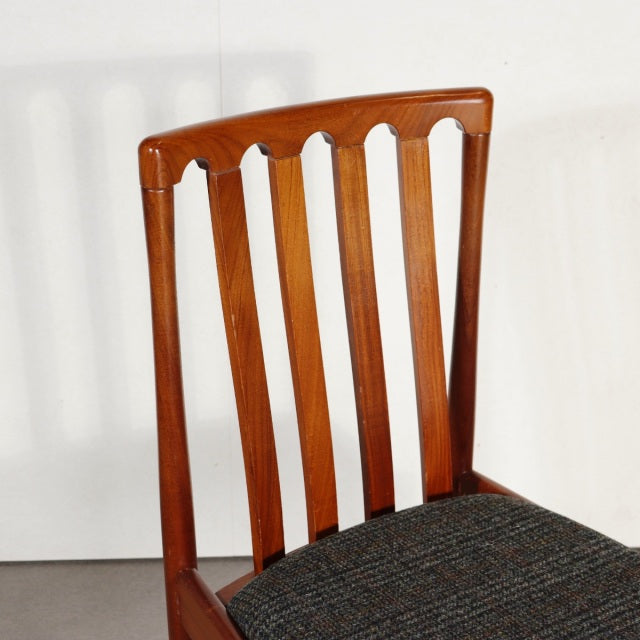 Vintage mid-century teak dining chair with British-Denmark design, vertical slatted backrest, and dark upholstered seat.