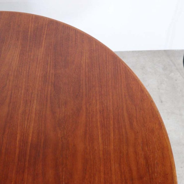 Round vintage teak dining table top showing rich wood grain and smooth surface, mid-century British design.