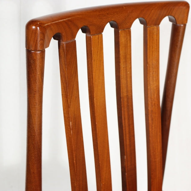 Mid-century British teak dining chair by MEREDEW with vertical slat back and smooth rounded edges, showcasing warm wood.