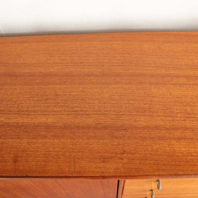Vintage teak sideboard top showcasing smooth mid-century wood grain with warm British-Danish craftsmanship.