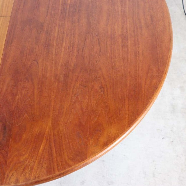 Vintage British mid-century teak dining table by Elliotts of Newbury with smooth rounded edge and rich wood grain visible on .