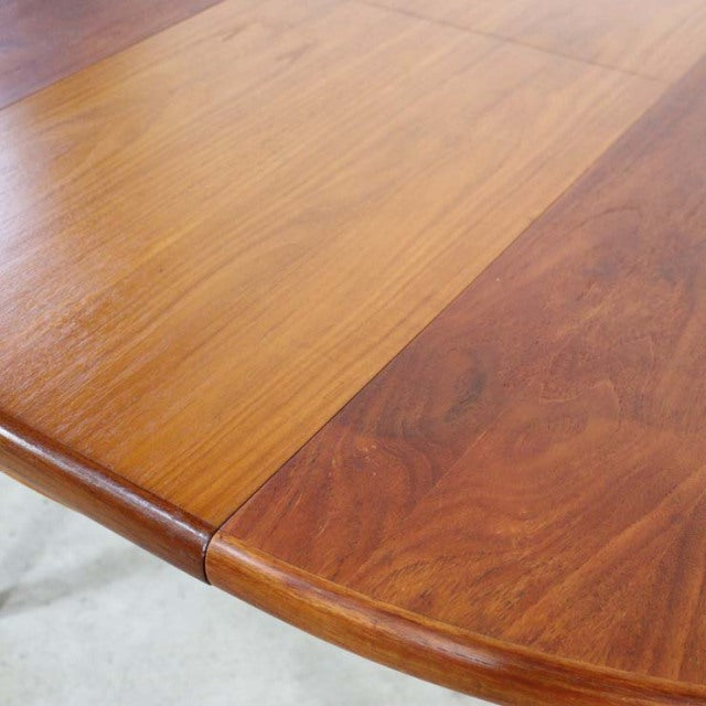 Oval vintage teak dining table top showing rich wood grain and smooth finish with rounded edges, British mid-century style.