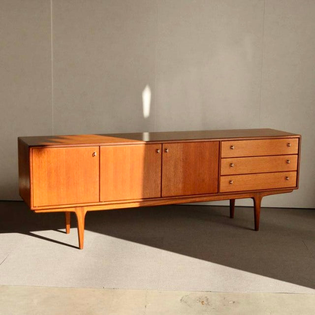 Vintage mid-century teak sideboard by Younger, British design with smooth wood grain, tapered legs, and a combination of.