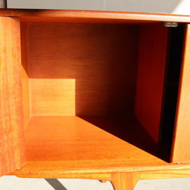 Vintage teak mid-century sideboard interior showing rich wood grain and smooth finish, British-Scandinavian style.