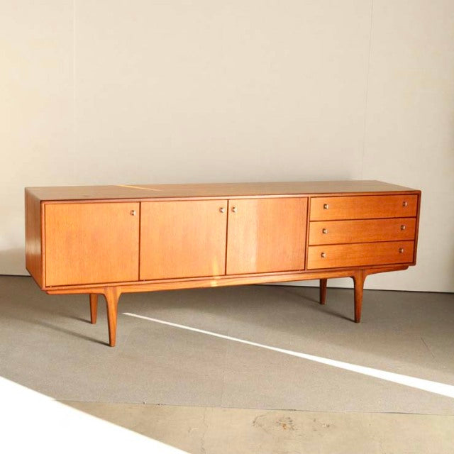 Vintage teak British mid-century sideboard by Younger with sleek tapered legs and smooth wood grain finish.